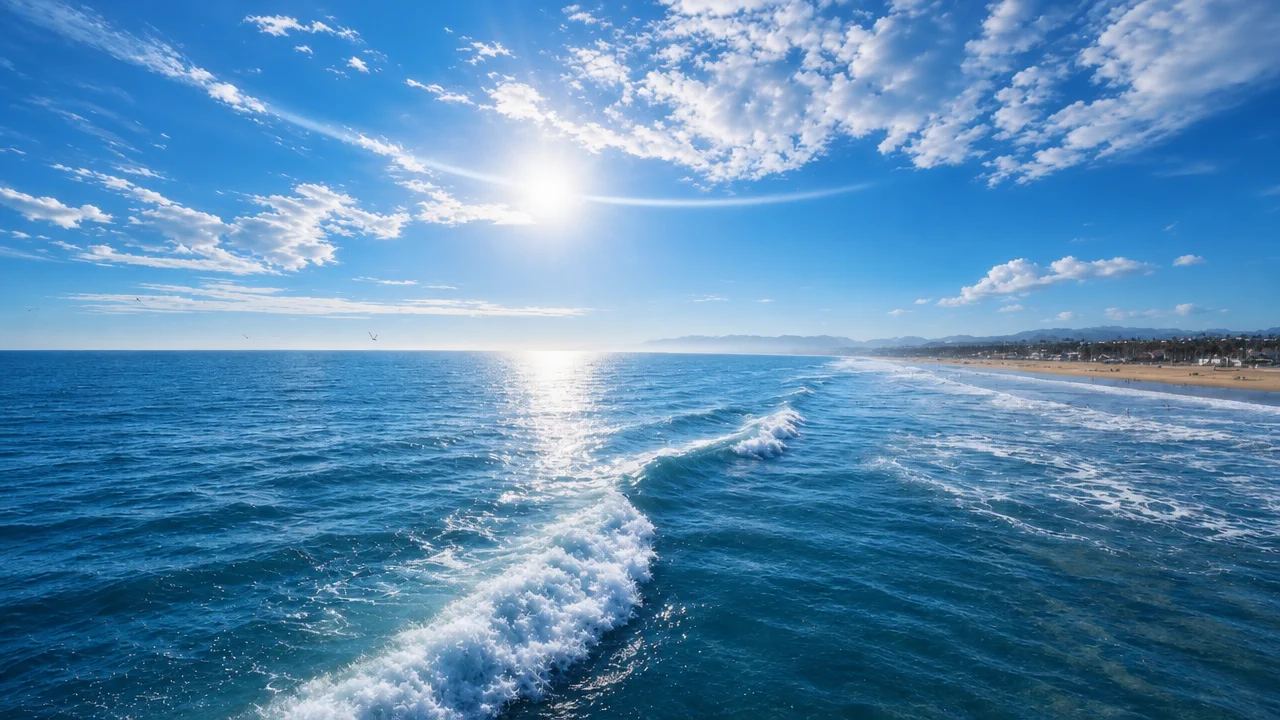 Bright sunlight over rolling ocean waves under a blue sky
